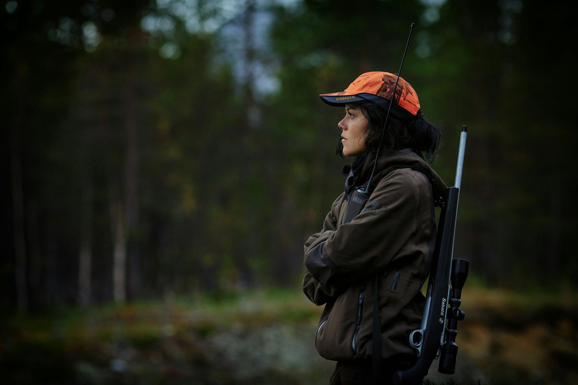 Lawful firearm owner in hunting gear carrying a scoped rifle in the Colorado backcountry